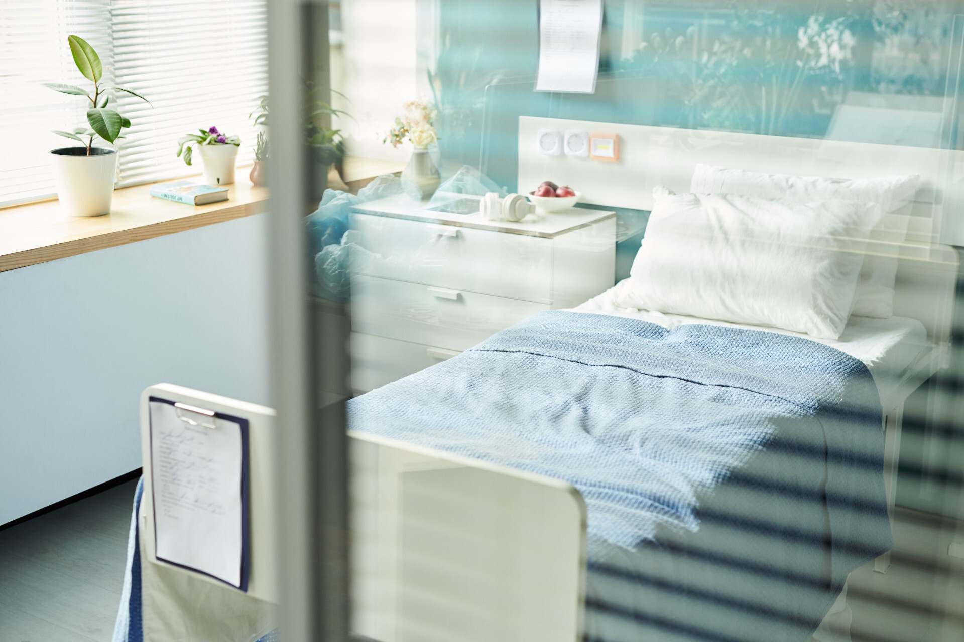 Chambre d'hôpital avec lit bleu.